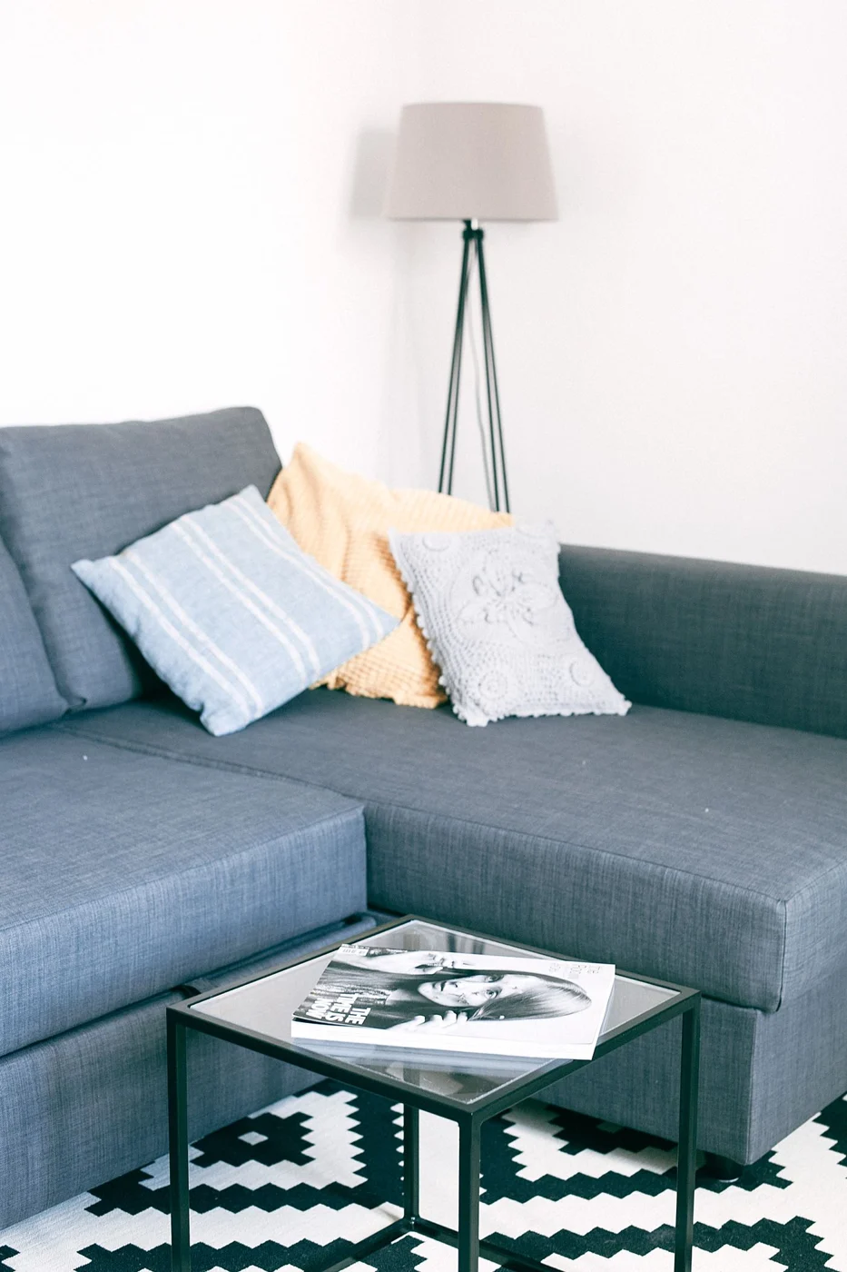 Sofa vor einem quadratischen Couchtisch auf einem Teppich