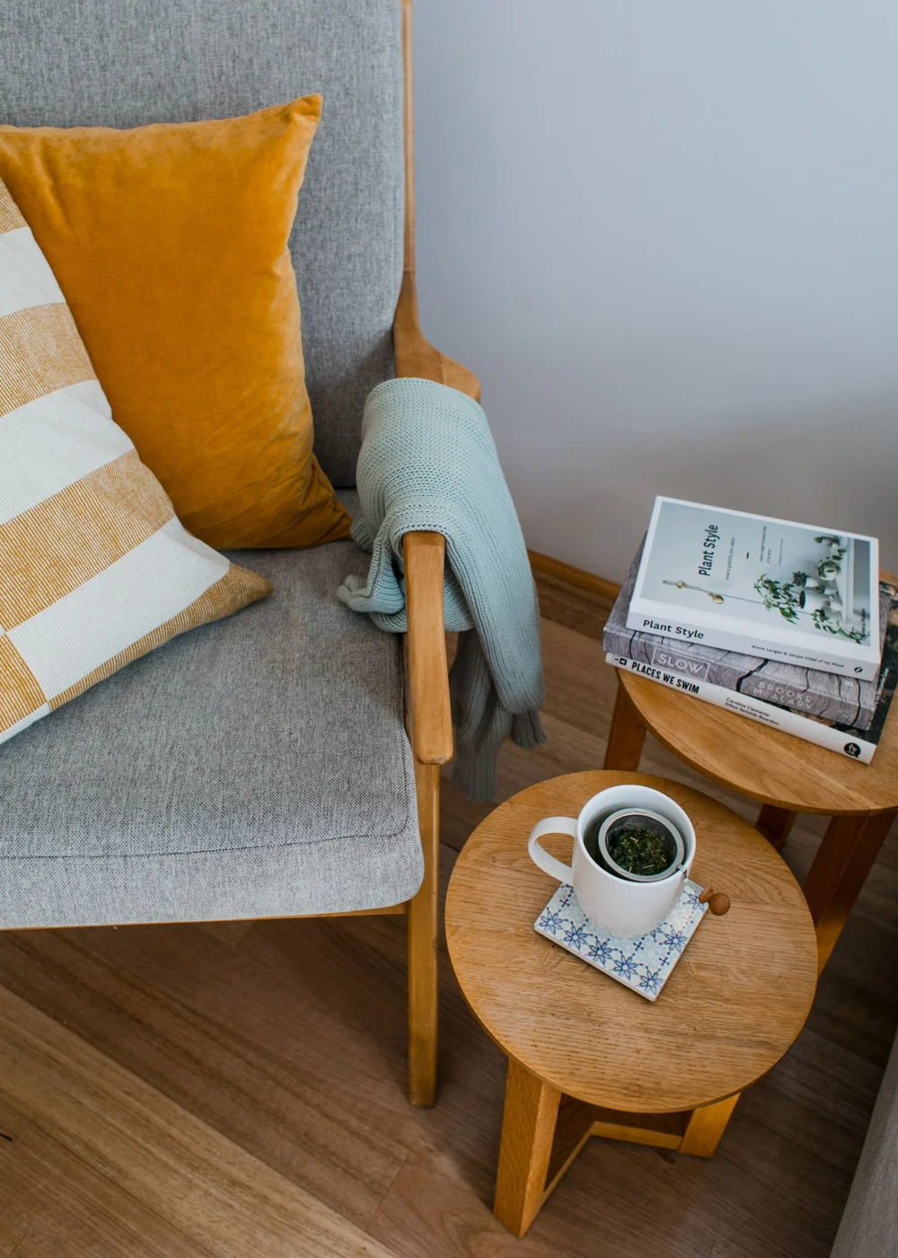 Beistelltische mit Büchern und einer Tasse neben einem Sessel