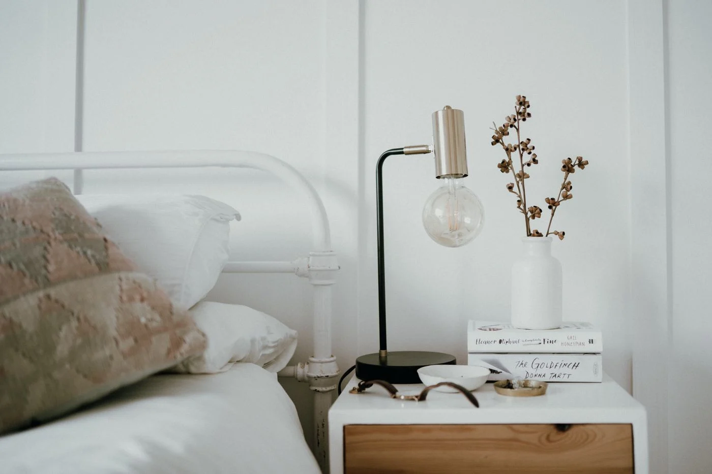 Nachttischlampe auf einem kleinen Tisch neben dem Bett