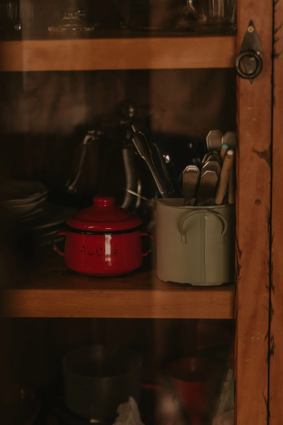 Kochgeschirr und Geschirr in einem Holzschrank
