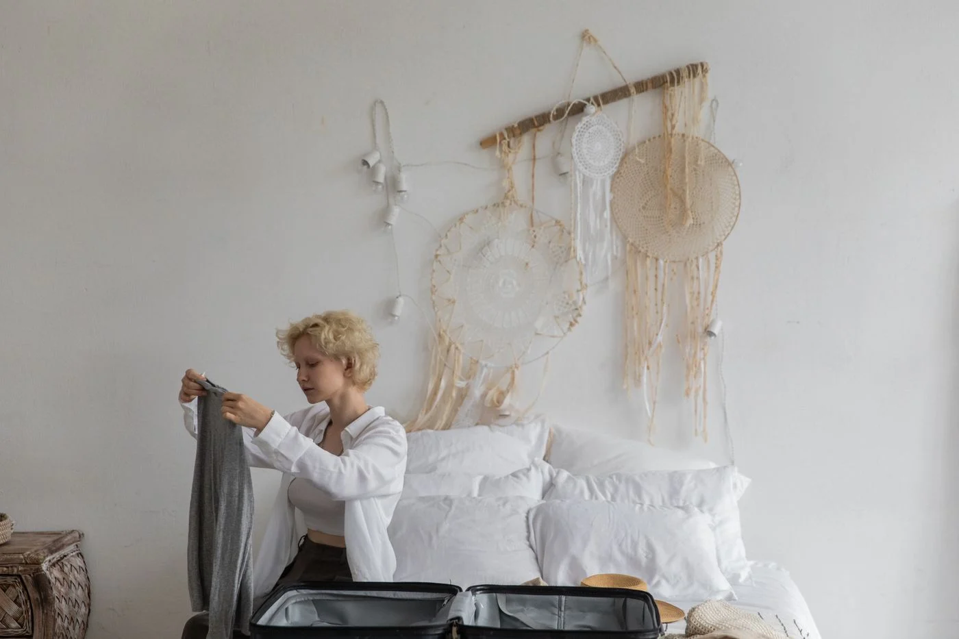 Geöffneter Koffer mit Kleidung auf einem Bett