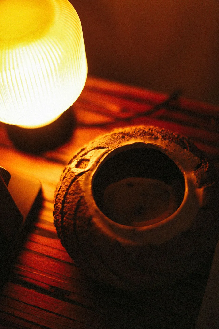 Tischlampe mit warmem Licht neben einer Vase