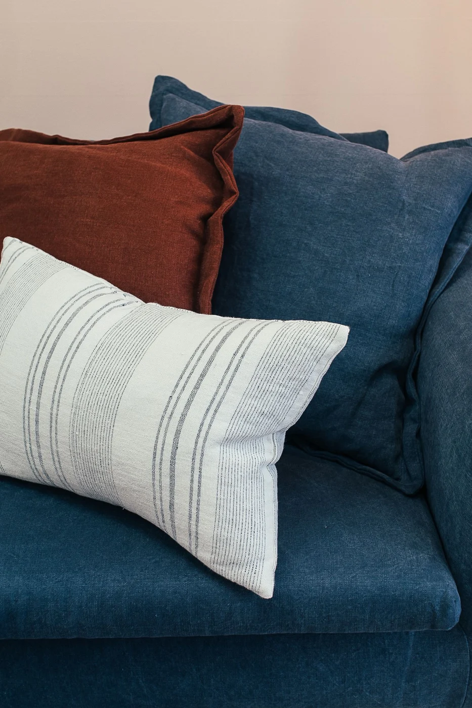 Blaues Sofa mit kontrastierenden Kissen