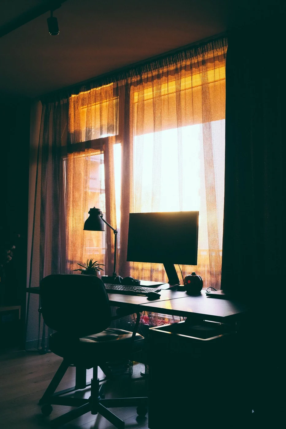 Monitor auf einem Schreibtisch neben einem Fenster