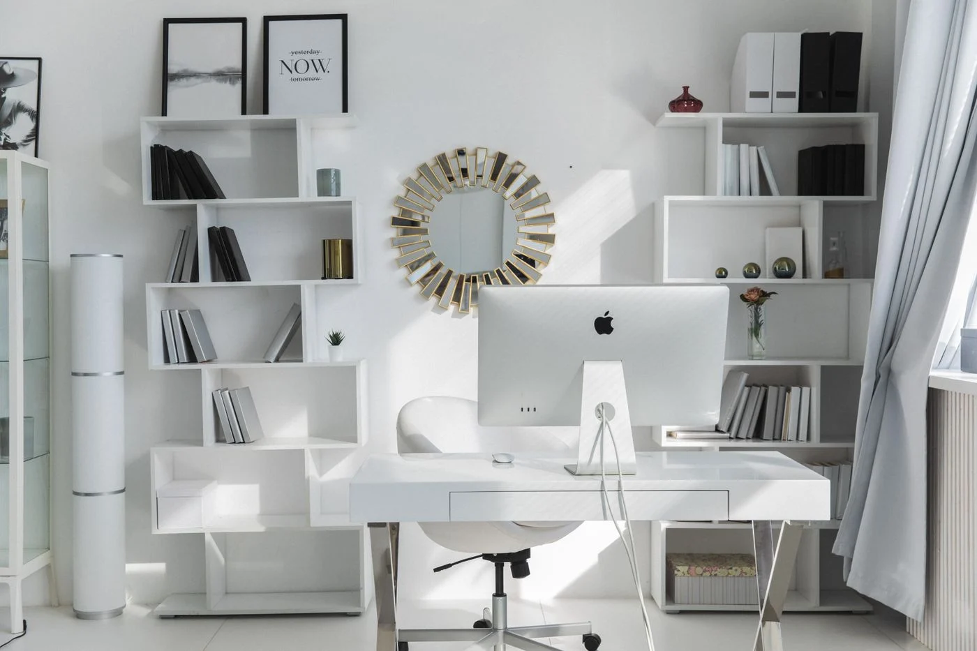 Weißer Schreibtisch und übersichtliche Regale im Arbeitszimmer