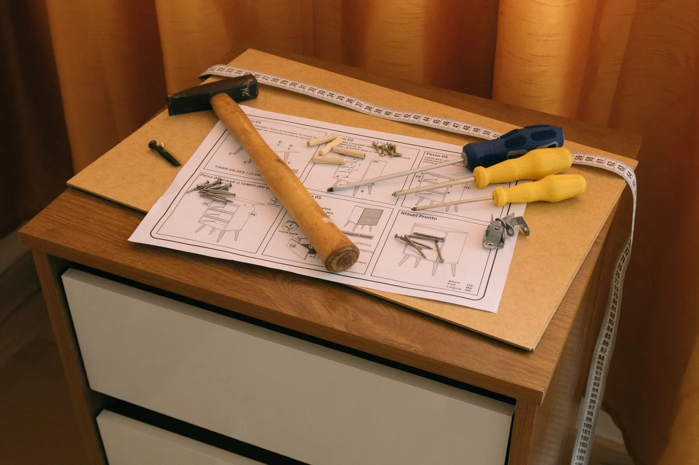 Möbelanleitung neben einem Schrank und Werkzeugen
